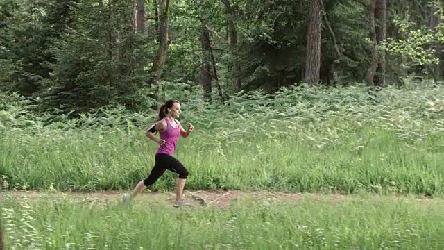 SLO MO DS女人在森林小径上奔跑