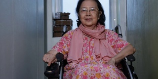 亚洲老年妇女移动自己的电动轮椅