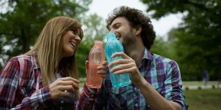 HD:年轻愉快的夫妇骑完自行车后喝水。