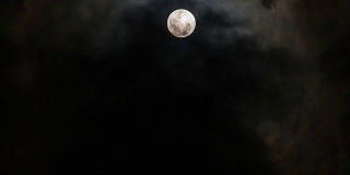 满月穿过云层。