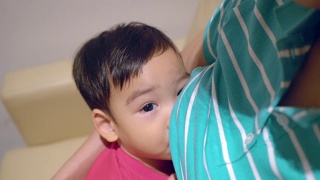 亚洲妈妈正在给她的儿子喂奶视频素材模板下载