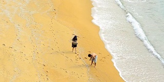 panning:浪漫的情侣帮忙在海滩上放东西