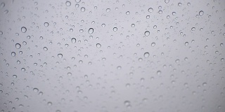在雨天，从车内透过挡风玻璃观看潮湿的城市