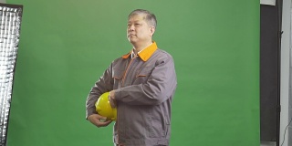 老亚洲人技术员工作制服和黄色安全帽4k