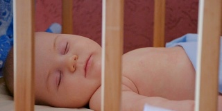 小婴儿睡在他的婴儿床里，靠近点