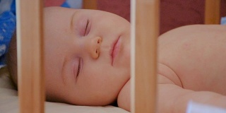 小婴儿睡在他的婴儿床里，靠近点