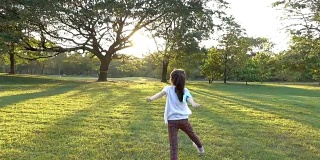 快乐亚洲小女孩在公园里跑步