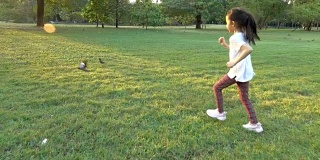 快乐亚洲小女孩在公园里跑去抓鸟