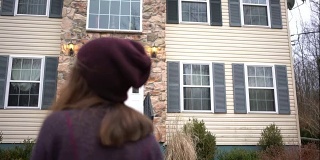 一个十几岁的女孩站在社区的房子前