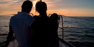 浪漫的情侣在日落时分航行