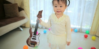 弹吉他的亚洲小女孩
