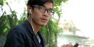 一名男子在公园里戴着耳机听音乐