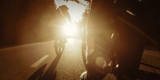 骑自行车的人的腿被太阳照亮，而骑在乡村道路上