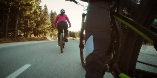 一对夫妇在乡村公路上骑自行车