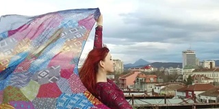 自由坚强的女人在山脚下看城市风景