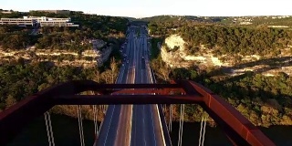 Pennybacker桥或360桥或首府德克萨斯州高速公路桥在日落科罗拉多河或镇湖春天时间空中直接飞过桥的顶部