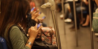 拥挤的公共交通工具上的人们在等待的时候使用手机