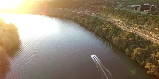 追逐快艇在德克萨斯州奥斯汀湖上的太阳空中跟随场景与船加速过特拉维斯湖或镇湖或科罗拉多河的水