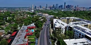 2016年，无人机飞越德克萨斯州奥斯汀市，从南Lamar大道，从天际线城市景观背景，公寓和屋顶，绿色地带春季美丽的首都城市视图