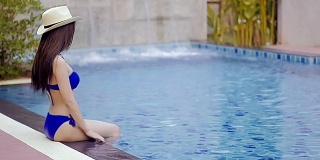 游泳池里的亚洲年轻女子。缓慢的运动。