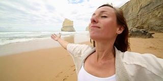 年轻女子的双臂伸展在吉布森海滩，澳大利亚