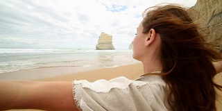 年轻女子的双臂伸展在吉布森海滩，澳大利亚