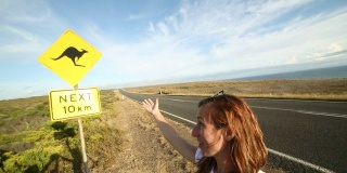 一名年轻女子与警示路标自拍合影——澳大利亚