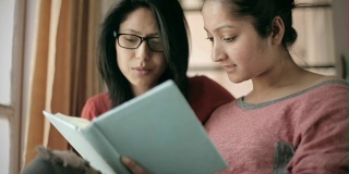 青少年晚期快乐的女孩学生一起学习书籍。