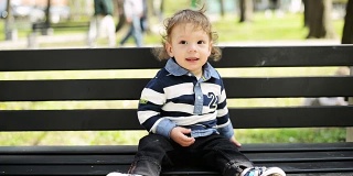 小男孩坐在长凳上