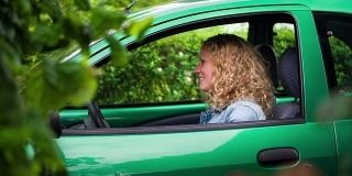 坐在绿色车里的女人展示她的车钥匙