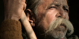 大胡子老人的画像，拿着竹竿。