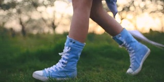 十几岁的女孩拿着长纸，走在长长的蓝色帆布运动鞋