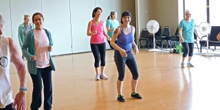 不同年龄段的女性在健身课上做有氧舞蹈