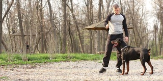 训犬师和杜宾犬一起锻炼。