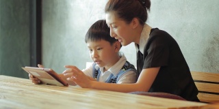 亚洲母亲和儿子使用平板电脑