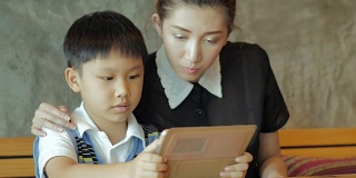 亚洲母亲和儿子使用平板电脑
