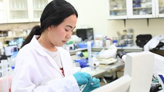 年轻的亚洲女科学家在实验室里用吸管工作视频素材模板下载