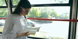 一位女士在有轨电车里读她最喜欢的书。