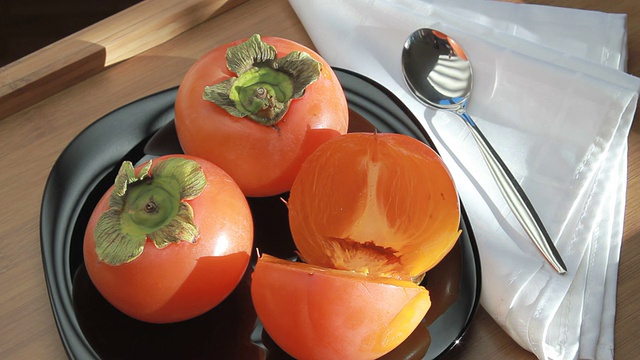 美味的熟柿子放在盘子里