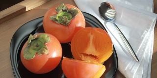 美味的熟柿子放在盘子里