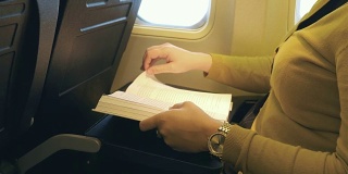 一个女人在飞机上看书的4K视频
