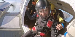 年轻的女跳伞运动员等着从飞机上跳下去