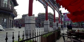 老北京典型的牌坊和前门购物街的步行者，中国北京