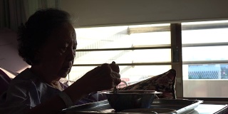 老年妇女病人在吃医院的食物