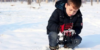 小男孩在雪里玩