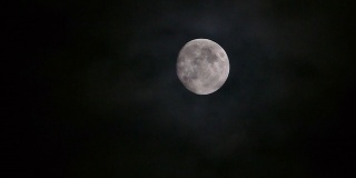 在起伏的云层后面的月球