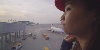 美丽的亚洲女人看飞机在香港机场