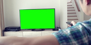男人看绿屏幕电视