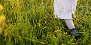SLO MO小女孩在草地上迈出第一步