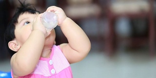 宝宝吃着米饭，喝着瓶子里的水